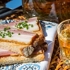 If salo had wings, it would fly to the heavens
Коли б сало крила мало, під небесами б літало
It is believed that eastern Slav tribes were conquered and subjected many times by steppe nomads from Asia. Nomads took their herds of horses, sheep, cattle, and goats. Short-legged pigs were less mobile and left behind. Thus, pork and salo saved Slavs when there was no other meat.
If I were a rich man, I’d eat salo with more salo on the side
Якби мені паном бути, то я б сало з салом їв
A piece of dark rye bread and thinly sliced salo is a traditional snack to accompany a shot of gorilka in Ukraine. For many Ukrainians, just thinking of it inspires salivation and reverence. It’s the delicacy Ukrainian immigrants smuggle when returning from Ukraine, and the funniest part is that U.S. customs officers know the word salo to ask for it. Ukrainians claim they can say what the pig was fed from the flavor of its salo, which seems tasteless for the rest of humanity.
In the Soviet Union, pigs raised on collective farms had a muscle-building diet, making the pork fat too tough and thin. The best Ukrainian salo was found at farmers' markets, coming from home-raised pigs, spoiled with milk and grain and secret ingredients to produce the luxurious fat that melted in the mouth like butter.
As stupid as salo without bread!
Дурне як сало без хліба!
Salo can be consumed raw or cooked. Aged salo and garlic are finely chopped and combined into a paste to flavor borscht at the end of cooking. Since salo is high-quality back fat, it is used in some traditional sausages. While small pieces of salo are slowly fried to render the fat for cooking, the crispy cracklings (Ukrainian shkvarky) are reserved to become toppings for other dishes.