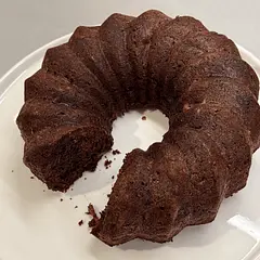 Chocolate Zucchini Bundt Cake (1.5×, Metric)

Oven & Pan
	•	Oven: 175°C
	•	Pan: 10–12 cup Bundt pan, well greased and dusted with cocoa powder

⸻

Ingredients

Dry
	•	212 g whole wheat pastry flour
	•	40 g unsweetened cocoa powder
	•	7.5 g baking soda (1½ tsp)
	•	≈2 g salt (⅜ tsp)

Wet
	•	42 g coconut oil, melted and cooled
(or olive oil)
	•	165 g honey, agave, or pure maple syrup
	•	7.5 ml vanilla extract
	•	75 g beaten egg
(crack 2 eggs, beat, and use about ¾ of the mixture)
	•	180 g finely shredded zucchini, well squeezed
	•	225 g mashed ripe banana
(or 90 g unsweetened applesauce)
	•	180 ml unsweetened vanilla almond milk

Add-ins
	•	135 g chocolate chips (regular or mini, dairy-free if desired)

⸻

Instructions
	1.	Preheat oven to 175°C. Generously grease a Bundt pan and dust with cocoa powder.
	2.	Grate zucchini finely, squeeze out excess moisture, then measure 180 g.
	3.	In a bowl, whisk together flour, cocoa powder, baking soda, and salt.
	4.	In a large bowl or mixer, combine coconut oil, sweetener, vanilla, and beaten egg until smooth.
	5.	Mix in zucchini, banana (or applesauce), and almond milk.
	6.	Add dry ingredients and mix just until combined.
	7.	Fold in chocolate chips.
	8.	Pour batter into prepared Bundt pan (do not exceed ¾ full).
	9.	Bake 40–50 minutes, checking at 40 minutes. A skewer should come out clean or with a few moist crumbs.
	10.	Cool in pan 15–20 minutes, then invert onto a rack to release.
	11.	Cool completely before slicing.