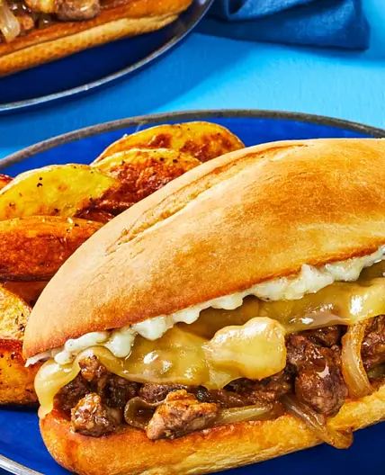 Cheesy Steak & Caramelized Onion Sandos with Potato Wedges and Roasted Garlic Aioli