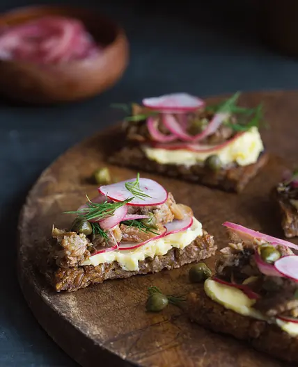 smoked herring on rye bread with radishes, salted butter, and pickled onions