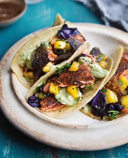 coffee-and-spice-rubbed salmon tacos with charred cabbage, mango salsa, and avocado cream