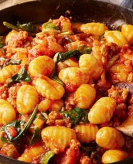 Ñoquis calientes de tomate y salchichas con hinojo y espinacas
