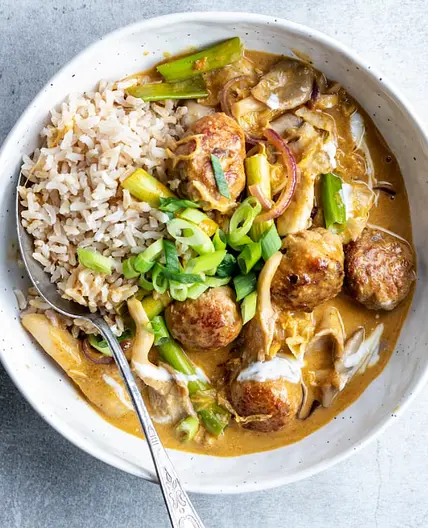 Kipballetjes in rode curry met rijst, witte kool en oesterzwam