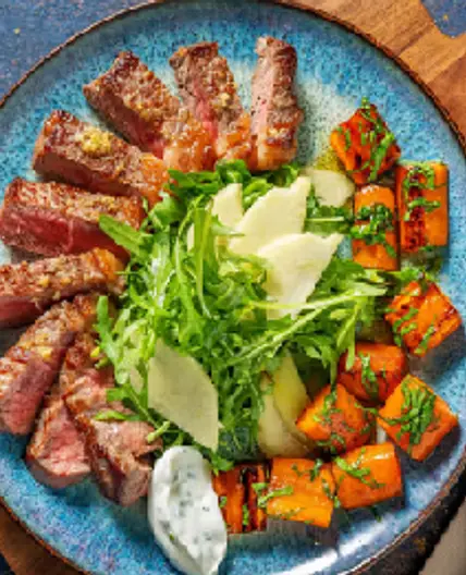Bistecca di manzo e carote al cumino con yogurt all'erba cipollina, mela e rucola