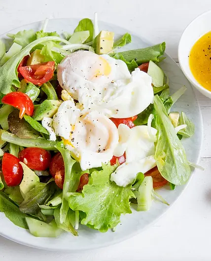 Pochierte Eier auf gemischtem Salat