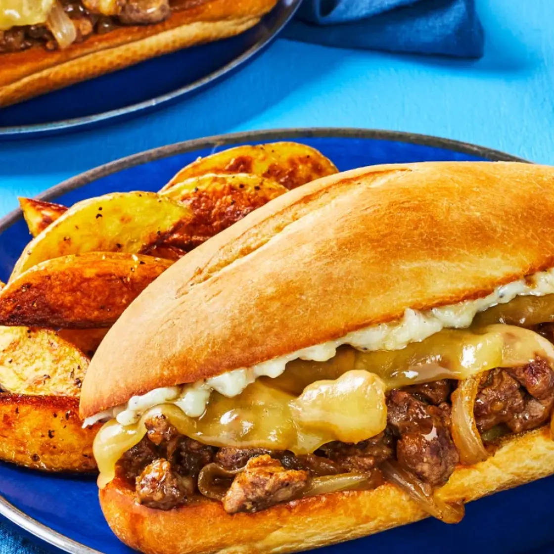 Cheesy Steak & Caramelized Onion Sandos with Potato Wedges and Roasted Garlic Aioli