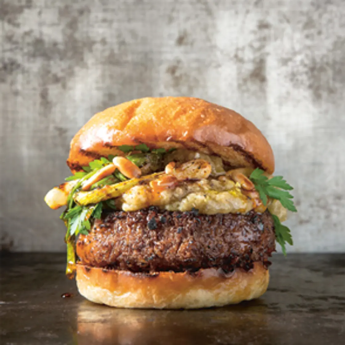 BLACK BEAN BURGER WITH BABA GHANOUSH, GRILLED SPRING ONIONS AND ROASTED PINE NUTS