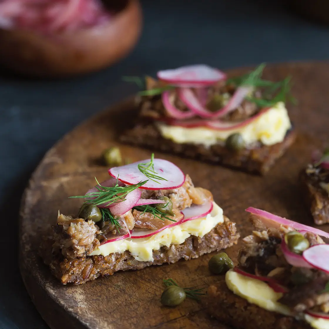 smoked herring on rye bread with radishes, salted butter, and pickled onions