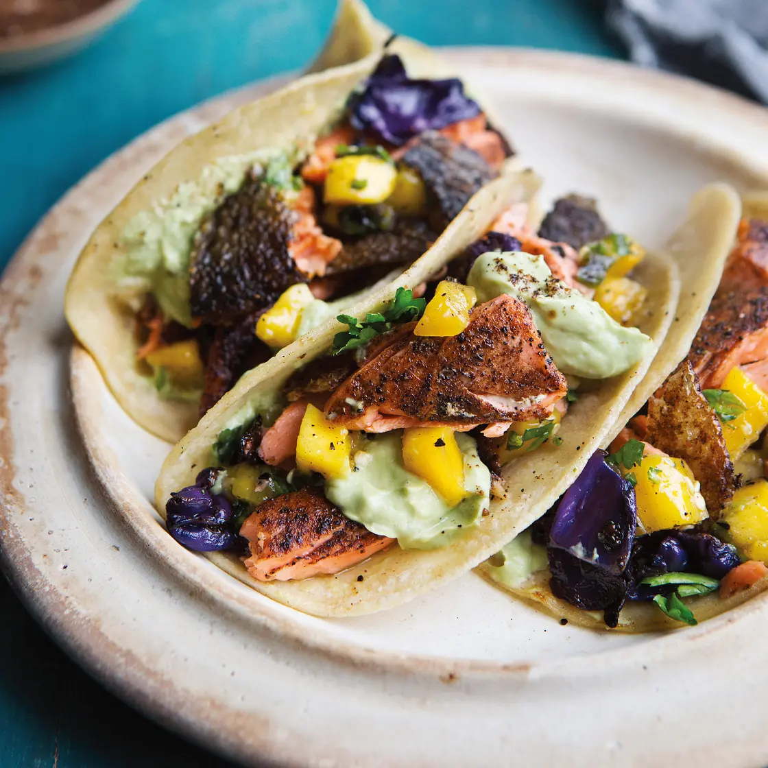 coffee-and-spice-rubbed salmon tacos with charred cabbage, mango salsa, and avocado cream