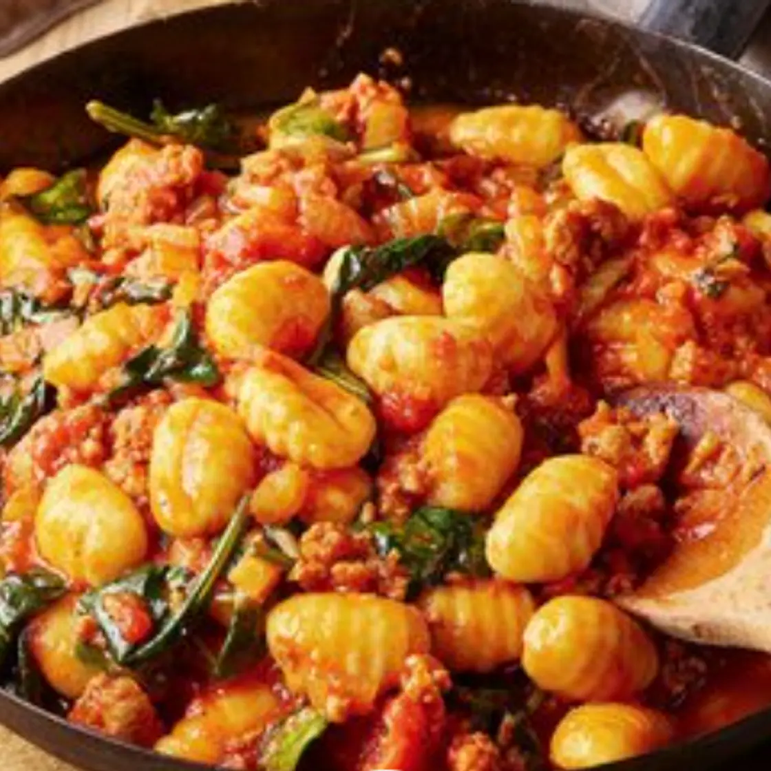 Ñoquis calientes de tomate y salchichas con hinojo y espinacas