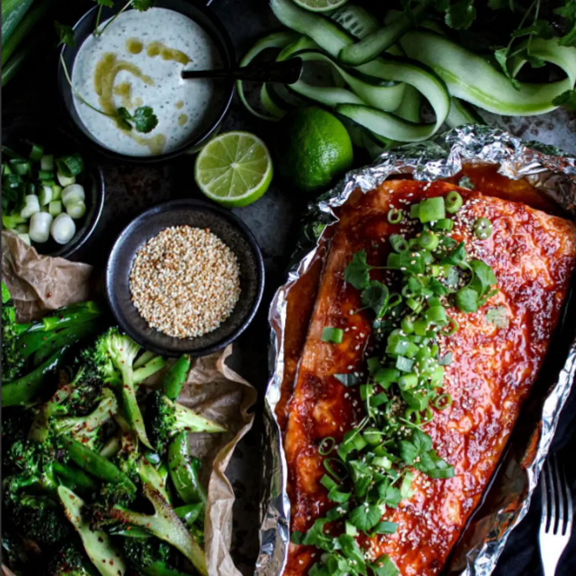 Ugnsbakad laxsida med honung och sriracha serveras med broccoli och en grön sriracha/koriandermajo