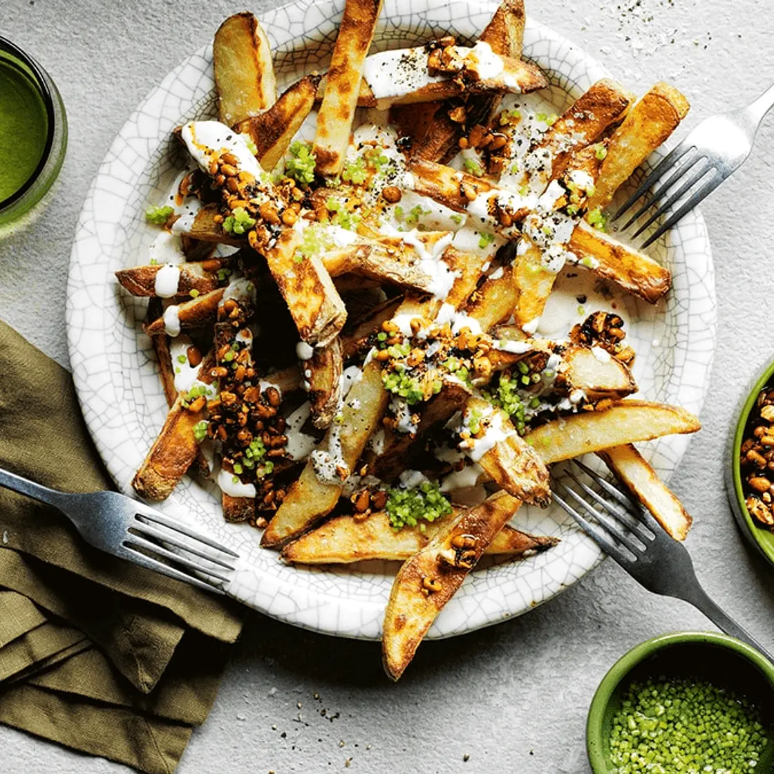 Yotam Ottolenghi's loaded fries with tahini yoghurt and smokey-sweet nuts