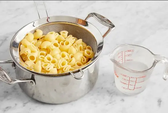 Meanwhile, add the pasta to the pot of boiling water. Cook, stirring occasionally, 5 to 7 minutes, or until al dente (still slightly firm to the bite). Turn off the heat. Reserving 1/2 cup of the pasta cooking water, drain thoroughly and return to the pot.