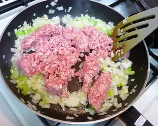 When the vegetables have wilted, increase the heat, then add the pork to the pan, stirring well until browned and crumbly.