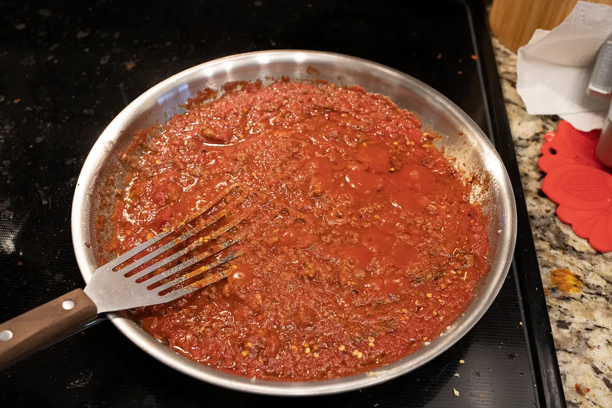 Next, add the crushed tomatoes, tomato paste and Italian seasoning. If you feel led, add as many roasted red pepper flakes as feels right for you. Bring it to a low simmer and let sit.