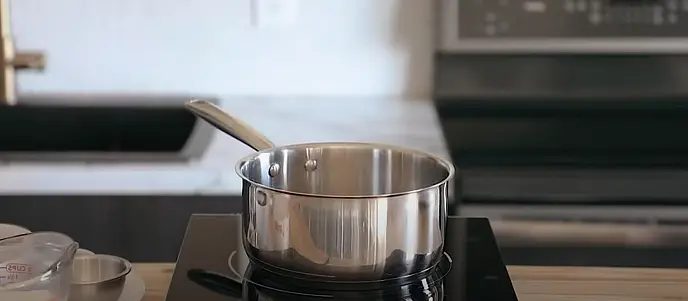 In a small saucepan, add finely chopped dark chocolate and a splash of whole milk. Begin heating over medium heat. Add 2 tbsp of granulated sugar and 1 tbsp of cocoa powder. Stir occasionally until melted.