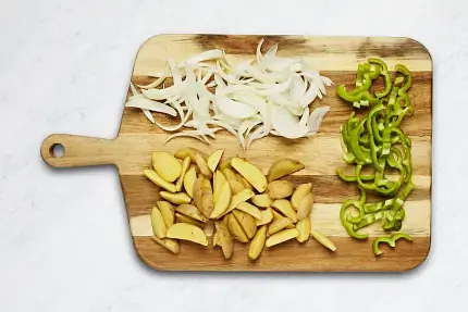 Adjust racks to top and middle positions and preheat oven to 450 degrees. Wash and dry produce. • Cut potatoes into ½-inch-thick wedges. Halve, peel, and thinly slice onion. Halve, core, and thinly slice green pepper into strips. • Pat chicken dry with paper towels; slice crosswise into ½-inch-thick strips.