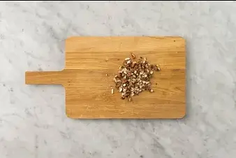 Arrosez le pain plat d'huile d’olive. Saupoudrez-le de poivre et éventuellement de sel au goût. Enveloppez-le dans du papier aluminium. Disposez-le sur l'autre moitié de la plaque de cuisson recouverte de papier sulfurisé, puis enfournez-le 1 à 2 minutes. Concassez grossièrement les amandes. Découpez le pains plat en 8.