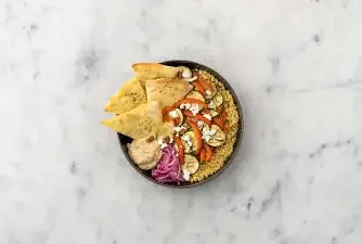 Servez la semoule dans des assiettes creuses. Disposez-y les rondelles de courgette et lanières de poivron rôtis. Égouttez l'oignon rouge mariné dans la passoire. Disposez l'oignon rouge et le baba ganousch sur les assiettes. Émiettez-y le fromage grec. Garnissez des amandes concassées et des parts de pain plat.