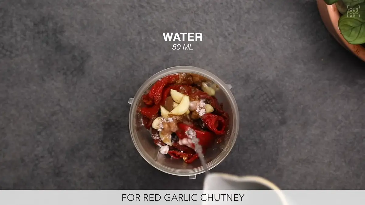 Add the soaked red chillies to a grinding jar and further add garlic cloves, black salt, jeera powder and salt to taste, add 50 ml water, grind into a fine paste. Make sure you do not grind the chillies when they are hot.