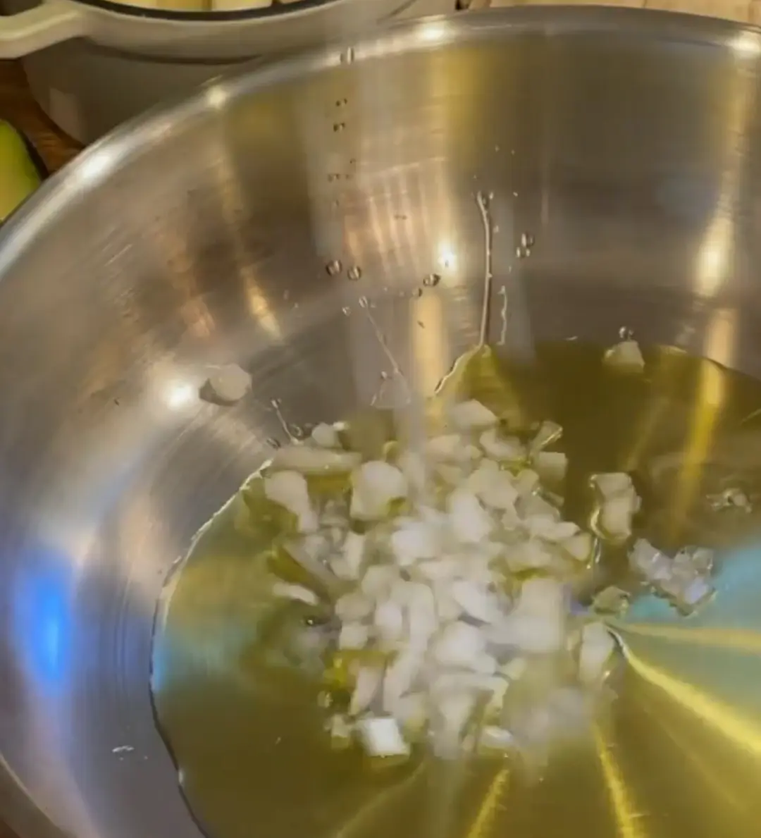 Agregar aceite de oliva al fondo de una sartén y saltear mitad de una cebollita (2-3 minutos), hasta que esté translúcida.