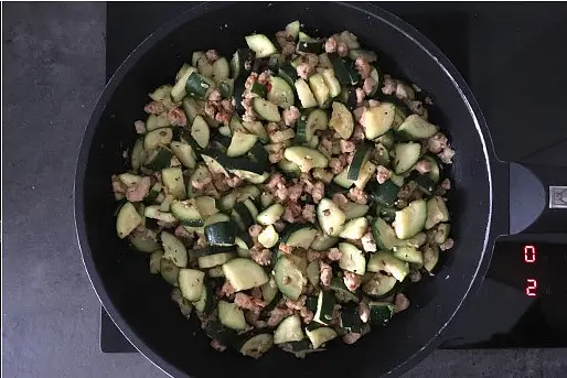 Calentar un poco de aceite en la misma sartén, añadir la pasta de tomate, las semillas con el ajo y dejar que se dore un minuto a fuego medio. Rápidamente echar el calabacín, salpimentar y saltear, removiendo constantemente hasta que esté dorado.