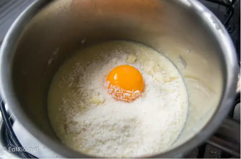 Place the condensed milk, coconut, butter/margarine, and egg yolk in a saucepan and mix well.