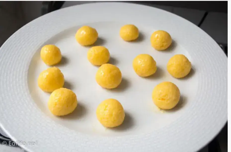 Spread mixture out on a plate to cool. Once the mixture is cool enough to handle, use a little butter to grease your hands, then take a teaspoon full of the mixture and roll it into marble sized ball. Repeat until you have used up all the coconut mixture. Leave the balls in the fridge or freezer to firm for up to an hour.