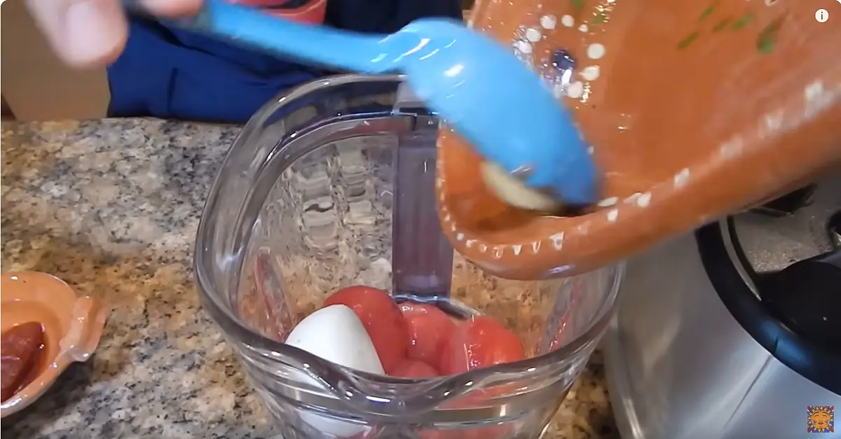 Peel the tomatoes and pu them in the blender with the onion, a garlic clove, chipotle chile, the just fried ancho chile, and some water