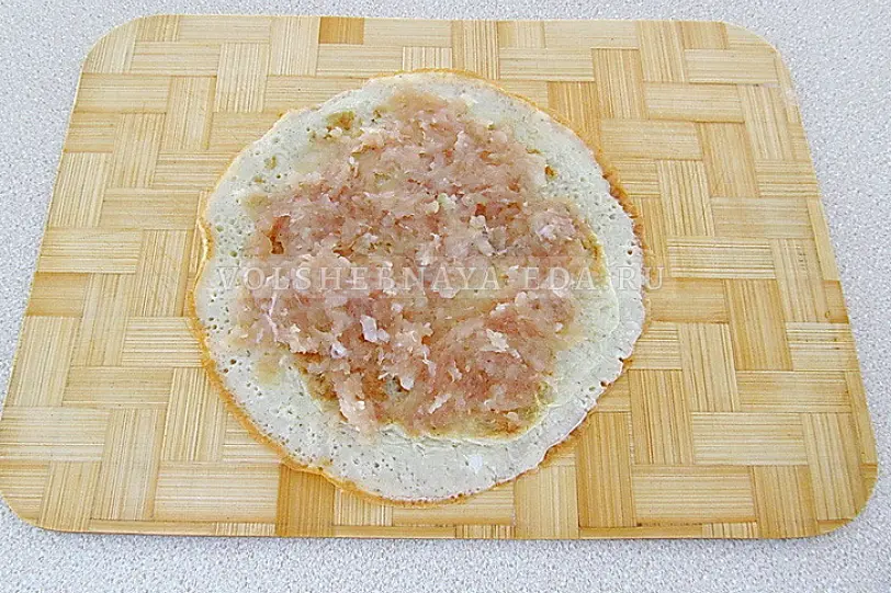 На середину каждого блинчика ровным слоем выложить куриный фарш.