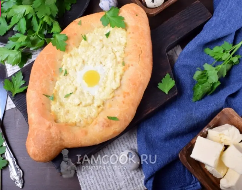 Смажьте края хачапури остатком куриного яйца, капнув в него немного воды или молока.
