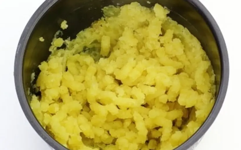 Картошка готова. Слить жидкость и хорошенько размять картофелемялкой.