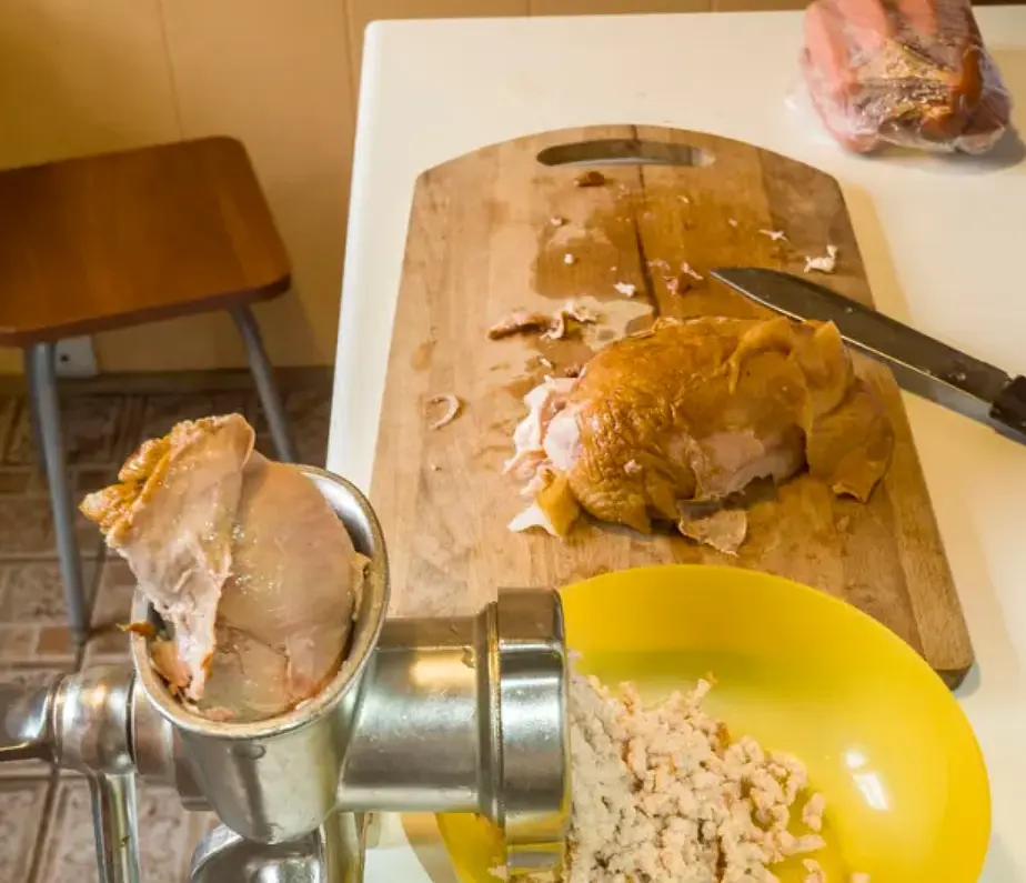 Куриную копченую грудку прокручиваем на мясорубке.