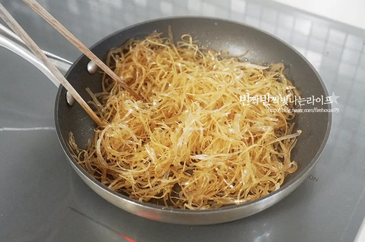 끓어오르면 불을 낮추어 전처리해둔 오징어채를 넣고 뭉치지 않고 골고루 간이 밸 수 있도록 저어가며 볶아줍니다.