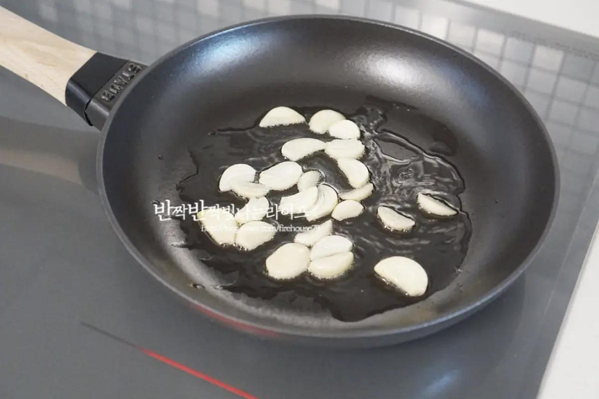 달군 팬에 식용유 1 큰 술 듬뿍 두르고 편으로 자른 마늘을 먼저 볶아줍니다.