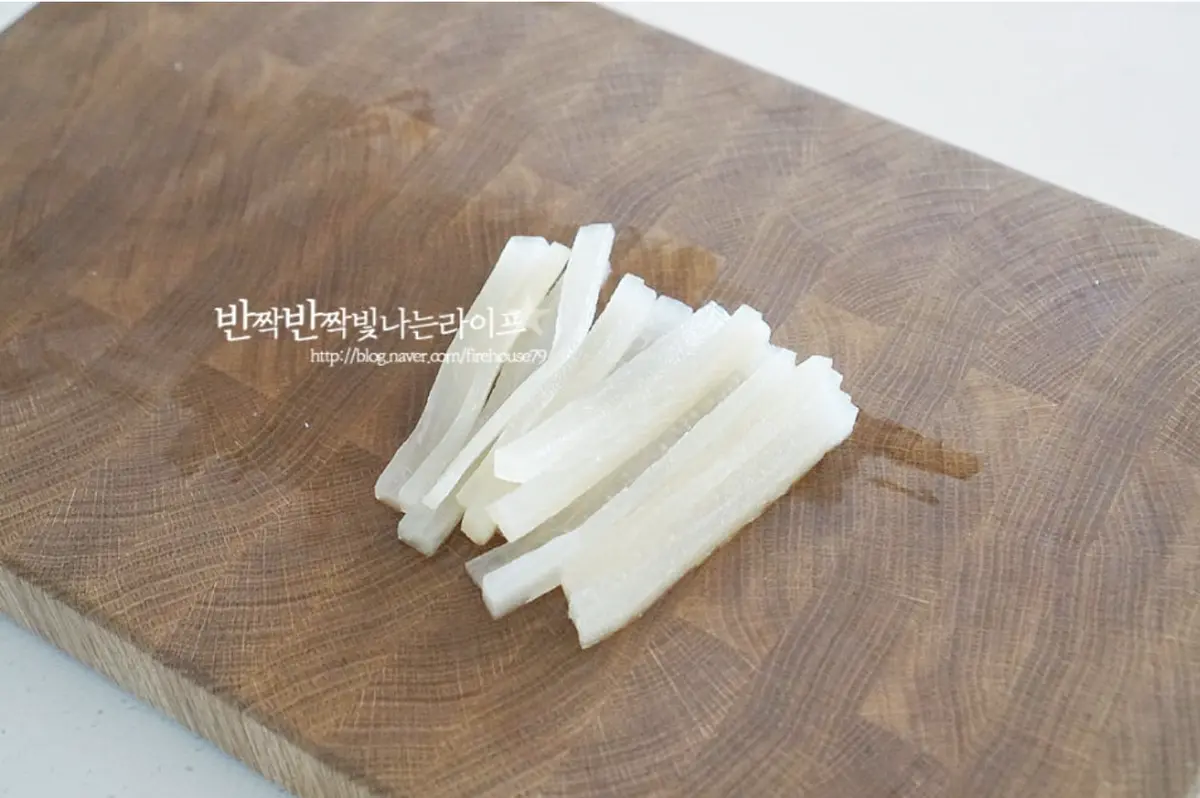 단무지는 물기를 털어주고 반으로 자른 뒤 길게 또 한 번 썰어줍니다.