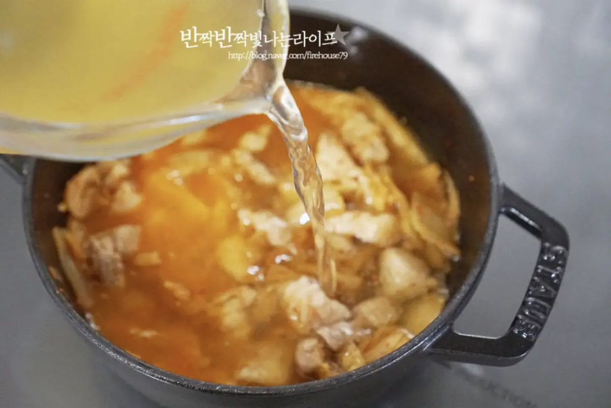 김치와 고기가 볶아지면 멸치 다시마 육수 500ml를 부어줍니다.