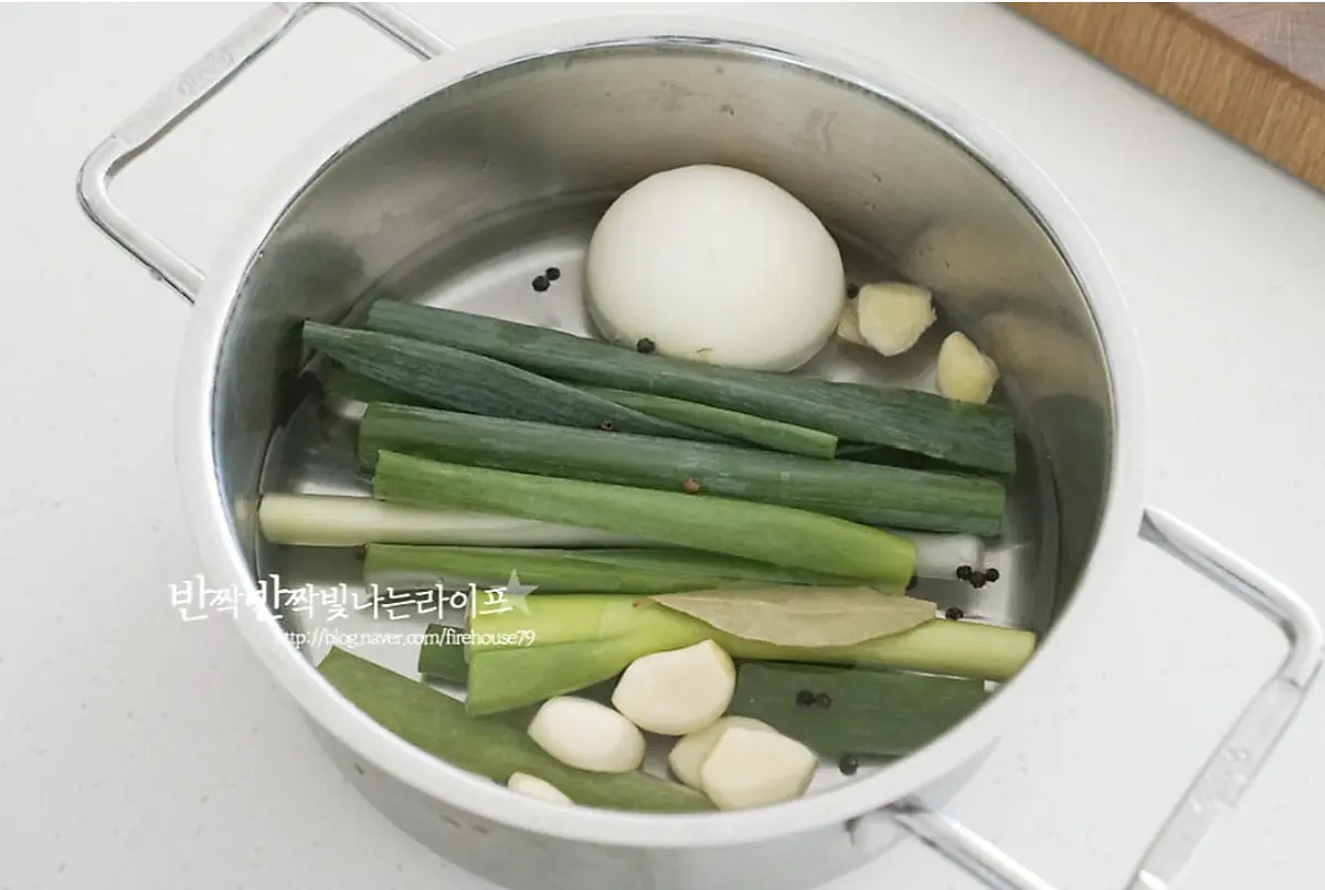냄비에 물 600ml를 붓고 대파 1대, 양파 1/2개 통마늘 8알, 생강 마늘 1알 크기 통후추 12알, 월계수잎 1장을 넣어줍니다.