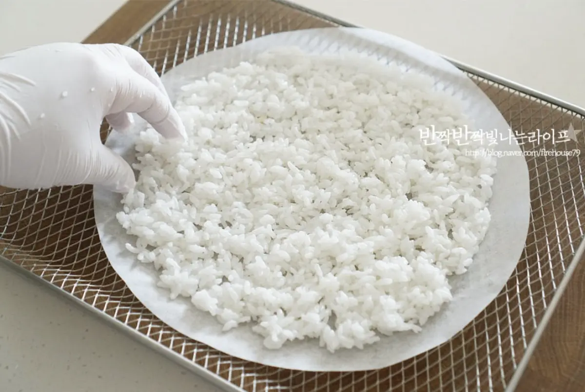 준비한 밥을 올려 살살 펼쳐가며 둥글 납작하게 해주고 물은 약간만 발라준 뒤 종이호일 위로 살살 펼쳐줍니다.