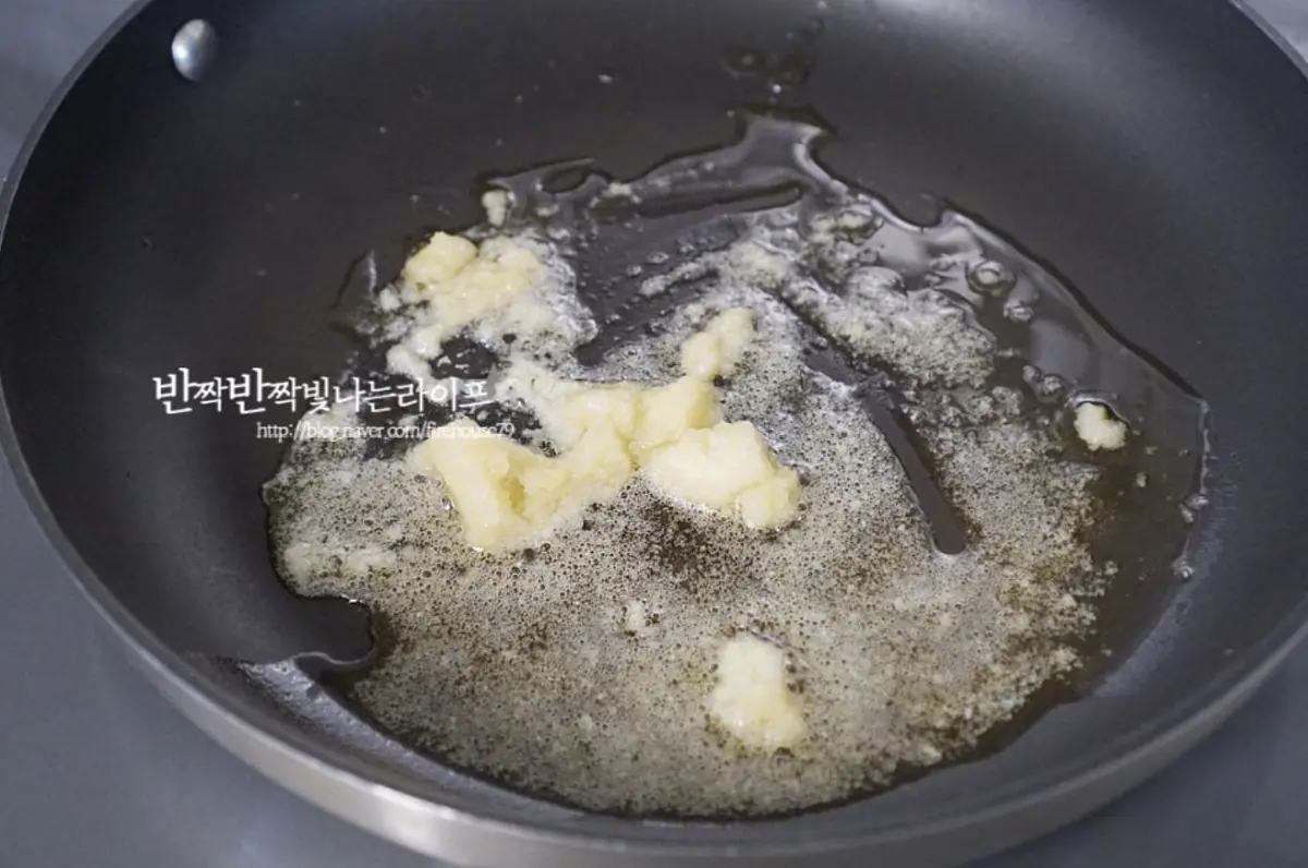 달군 팬에 식용유 3 큰 술 넉넉히 두르고 간 마늘 1 큰 술을 넣어 향을 내어줍니다.