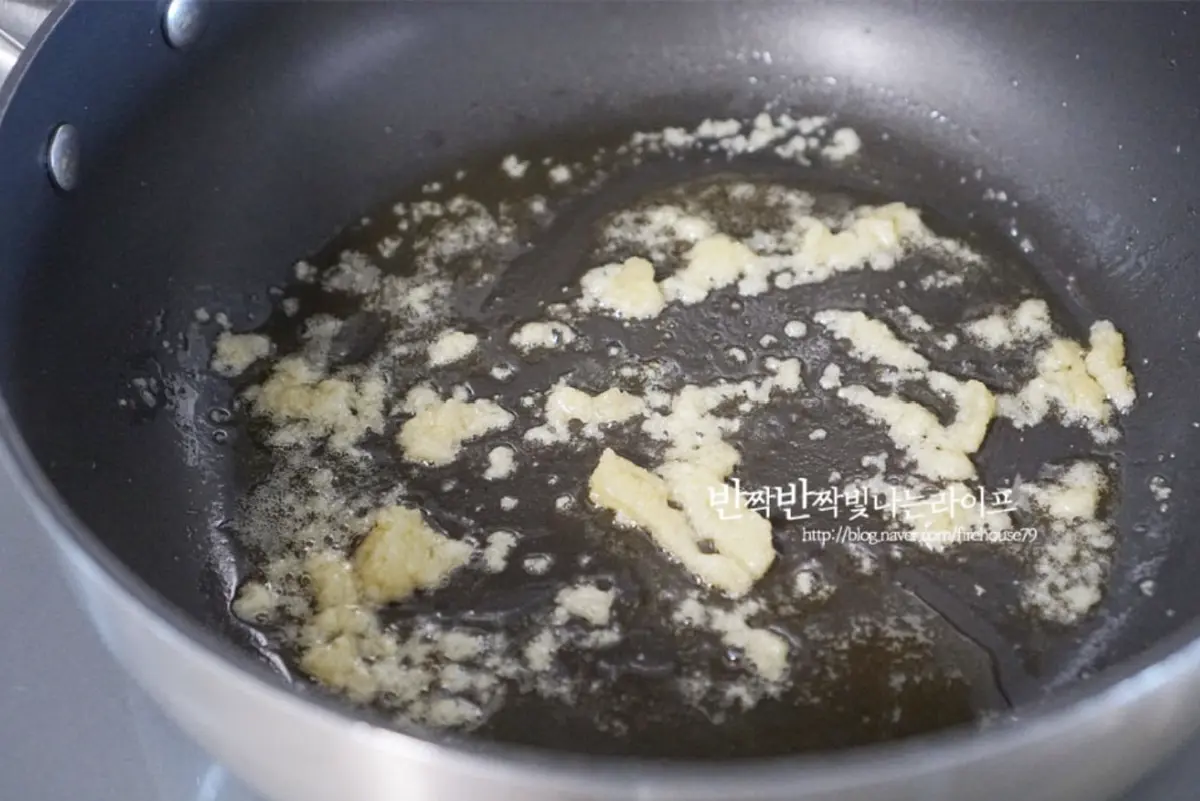 달군 팬에 식용유 1 큰 술을 두르고 간 마늘 1/2 큰 술을 넣고 향을 내어 볶아 줍니다.