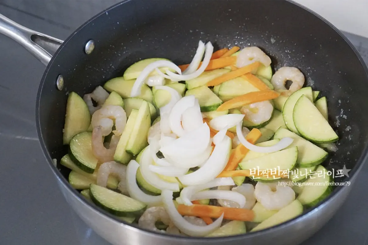 새우가 색이 변하고 익으면 애호박을 넣고 볶아주고 호박이 어우러지면 당근과 양파도 넣어줍니다.