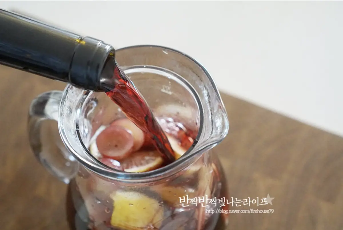 넉넉한 크기의 유리병에 설탕을 버무린 과일을 넣고 착즙해두었던 과일즙과 레드와인을 부어줍니다.
