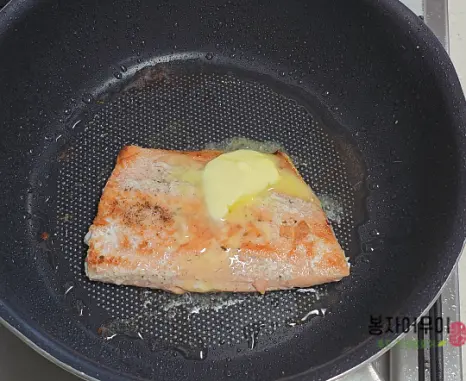 연어가 노릇해지면 버터를 올려서 골고루 발라주세요.