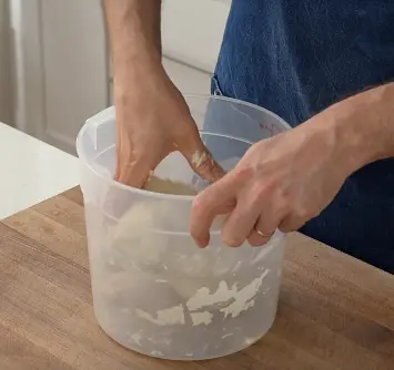 2. Stir with a sturdy spoon for 15 seconds until a shaggy mass forms. Wet your hand and squeeze the dough until it is homogenous.