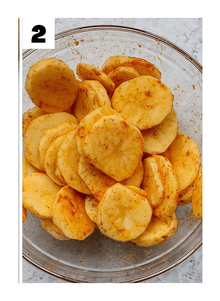 2. Toss slices in a bowl with olive oil, garlic granules, mixed herbs, and salt.