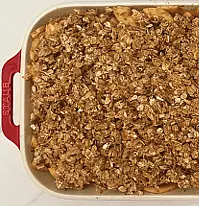 Sprinkle the crumb mixture over the top of the apples. Bake for 25-30 minutes on a baking tray until the topping is golden brown and the apples are soft. Let the crisp cool for 10 minutes. Serve with a scoop of vanilla ice-cream or whipped cream.