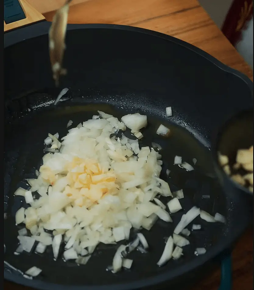 Dans un wok, mettre des oignons et de l'ail, faire cuire
