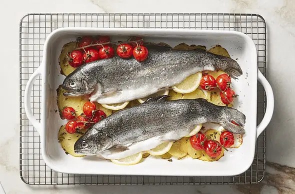 Arrange fish on top of potatoes, shifting tomatoes alongside. Roast until fish are cooked through, about 20 minutes; serve immediately.