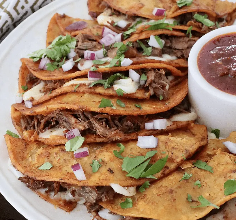 Quesabirria Tacos - Dip corn tortillas into the red chili oil skimmed from the top of your consomé. Fry them in a hot skillet, load with shredded cheese (like Oaxaca, Mozzarella, or Monterey Jack) and your shredded beef, then fold and crisp up.